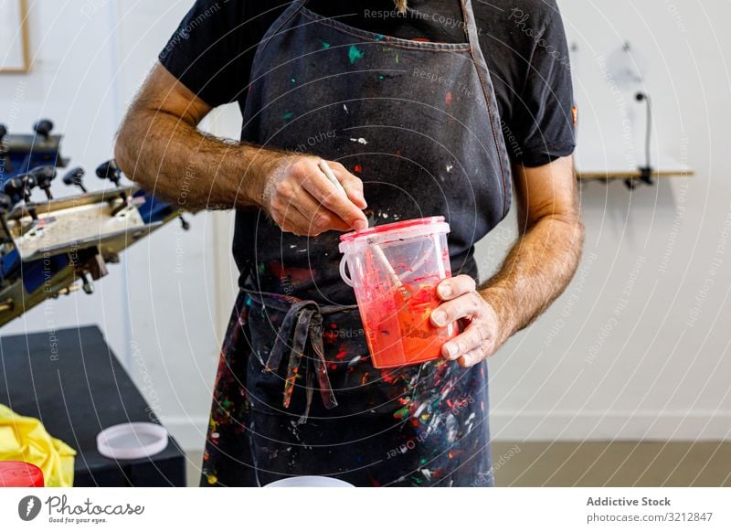 männlicher Künstler bei der Vorbereitung von Farben mischen Werkstatt erschaffend Serigraphie Bildschirm drucken Zeichnung dreckig Schürze Beruf Mann