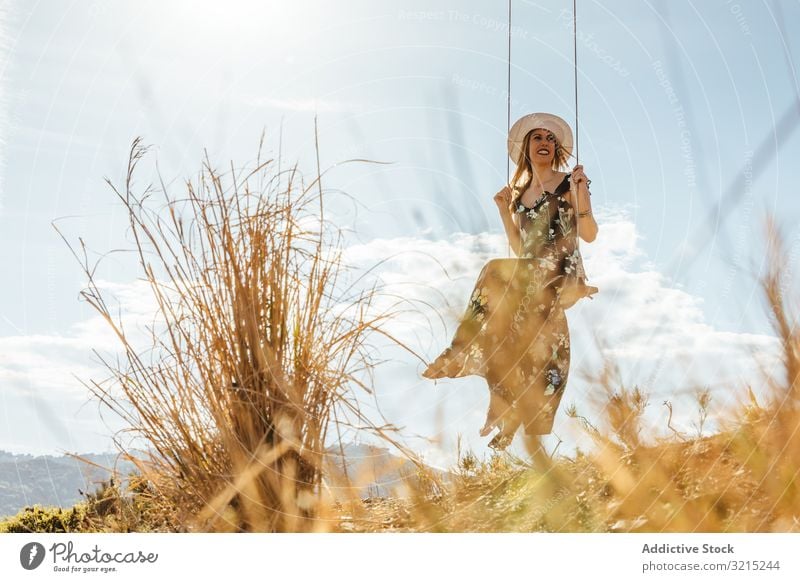 Glückliches Mädchen genießt auf einer Schaukel bei Sonnenuntergang pendeln Frau Fröhlichkeit Natur schön Silhouette jung Lifestyle Urlaub Landschaft Sommer