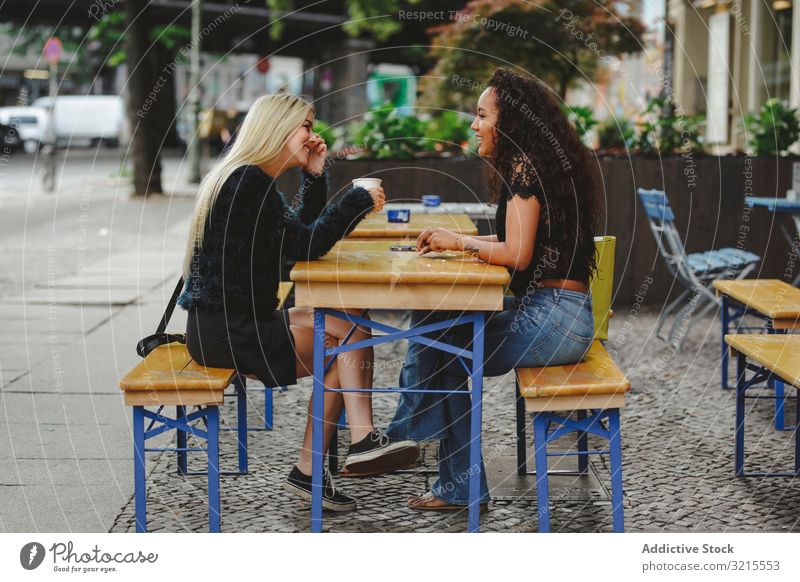 Freunde unterhalten sich im Straßencafé Frau Café reden Berlin schön Lächeln Glück Zusammensein Freizeit Genuss Restaurant rassenübergreifend hübsch Gespräch