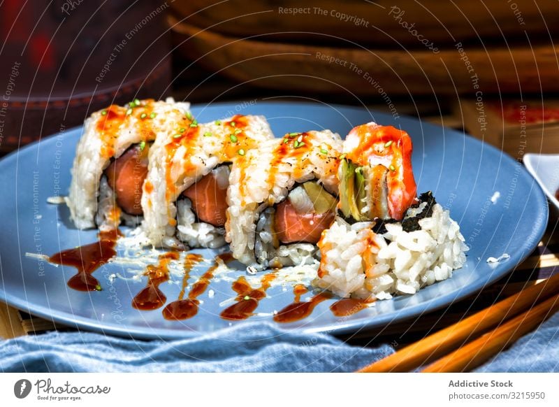 Leckere Sushi mit Sauce auf blauem Teller grün geschmackvoll Gastronomie serviert Fisch lecker appetitlich Restaurant asiatisch Lebensmittel Abendessen Lachs