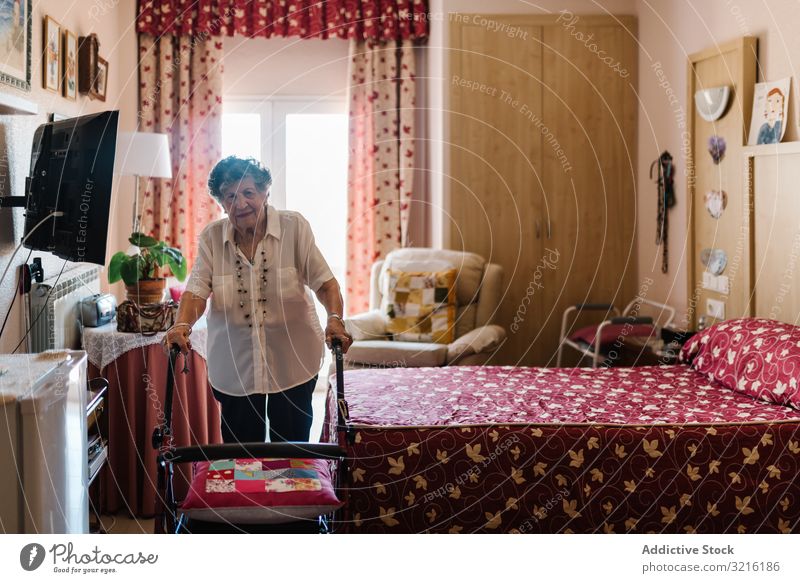 Ältere Frau mit Gehhilfe im Schlafzimmer gealtert Park Erfahrung Weisheit Aktivität Gesundheit Übung Großmutter Aufmerksamkeit Großeltern Generation Senior