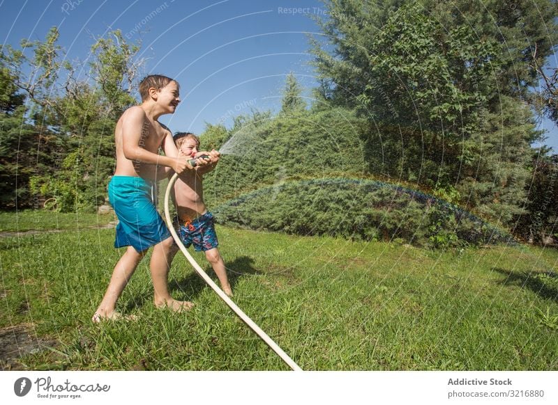 Kleine Kinder in Badebekleidung haben Spaß mit Spritzwasser Geplätscher Wasser Sommer Spielen Glück Beteiligung Lifestyle Freizeit Erholung Feiertag Kindheit