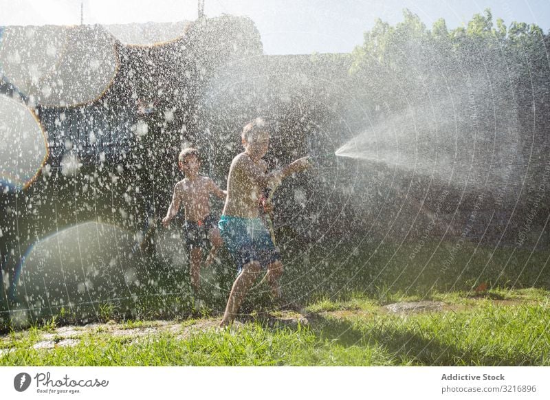 Kleine Kinder in Badebekleidung haben Spaß mit Spritzwasser Geplätscher Wasser Sommer Spielen Glück Lifestyle Freizeit Erholung Feiertag Kindheit Freude Genuss