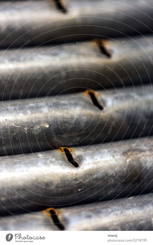 Verzinkte Eisenrohre mit Schlitzen Rost verzinkt Außenaufnahme abgenutzt aussortiert parallel Schwache Tiefenschärfe eingedrückt Schrott
