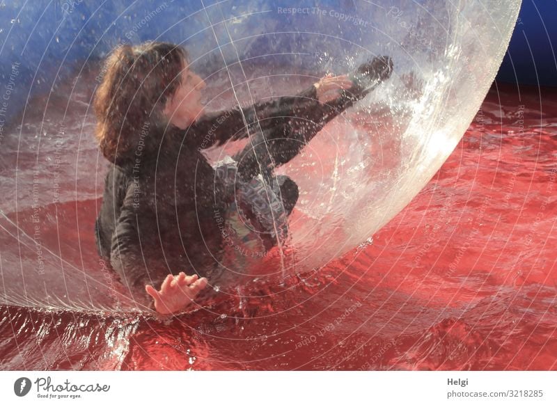 Frau mit brünetten langen Haaren bewegt sich in einer großen Plastikkugel in einem Wasserbecken Mensch feminin Erwachsene 1 45-60 Jahre T-Shirt Rock