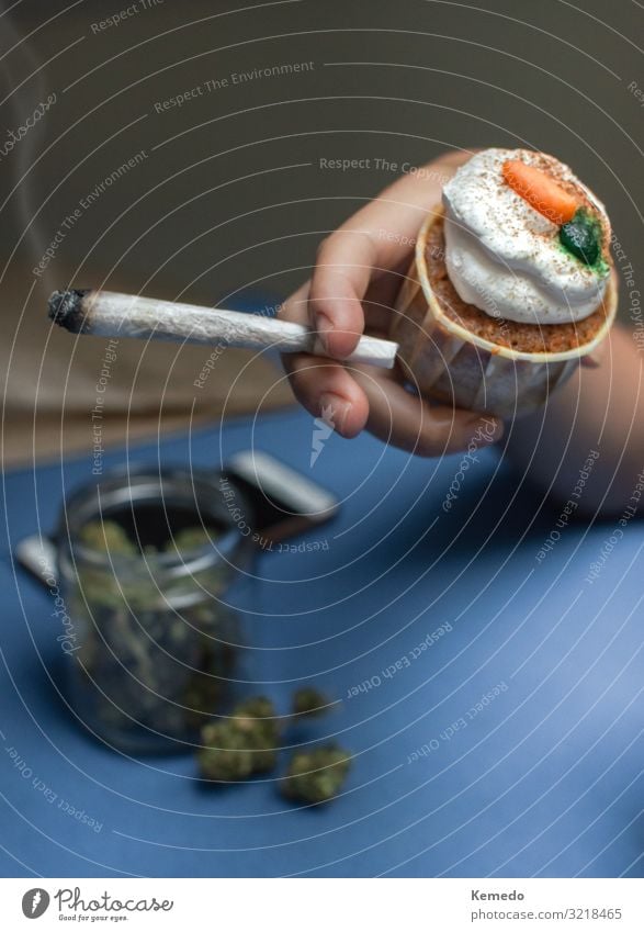 Hand mit einem Joint aus Marihuana und Kuchen aus Cannabis. Süßwaren Frühstück Lifestyle Freude Alternativmedizin Übergewicht Rauchen Rauschmittel Wellness