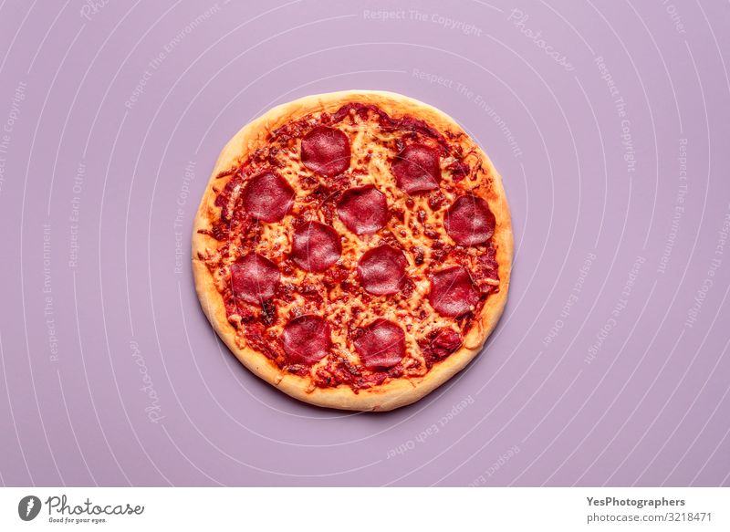 Ganze Pizzasalami auf violettem Hintergrund Hausgemachte Peperoni-Pizza Lebensmittel Fleisch Käse Teigwaren Backwaren Abendessen Büffet Brunch Fastfood