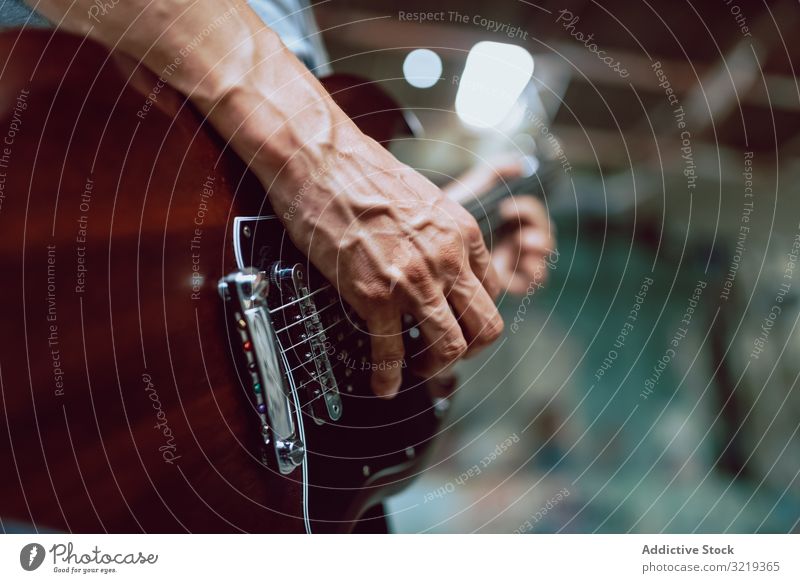 Mann spannt Saiten am Gitarrenhals ein Musiker elektrisch Hals Schnur Verschluss Leistung Griffbrett Instrument Entertainment spielen männlich Klang Felsen live