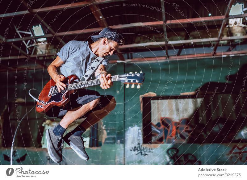 Musiker spielt E-Gitarre an verlassenem Ort Mann elektrisch springen Grunge Metall Leistung Verlassen Graffiti schwer auflehnen Instrument jung Entertainment