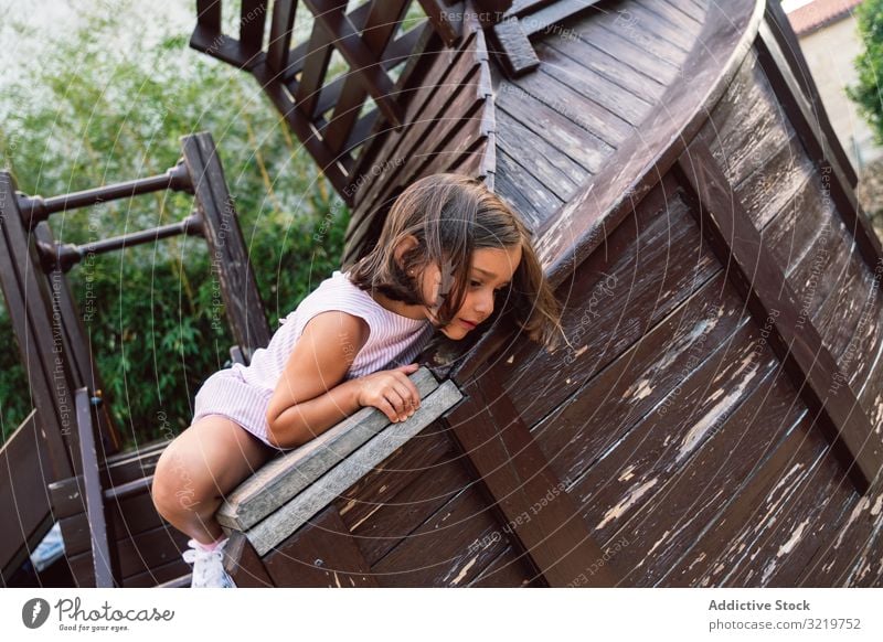 Lächelndes Mädchen klettert auf Holzspielplatz Kind spielen Aufstieg Spaß Spielplatz Aktivität Sport Glück wenig Entertainment Park Mut Lifestyle spielerisch