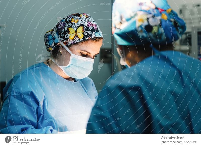 Konzentrierte Chirurgin bei der Arbeit Frau Arzt Chirurgie Krankenhaus Operation Medizin Beruf Konzentration jung ernst achtsam chirurgisch Kleid blau