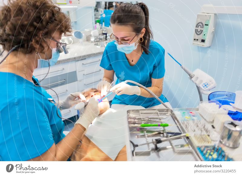 Zahnärzte mit Maske dichten den offenen Mund des Patienten auf dem Stuhl ab geduldig Zahnarzt Siegel arbeiten Operationshandschuhe Dentalwerkzeug Behandlung