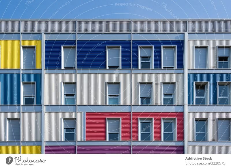 Fassade eines modernen mehrfarbigen Gebäudes mit schmalen Fenstern Außenseite farbenfroh Architektur Haus Anwesen Konstruktion Investition wohnbedingt Struktur
