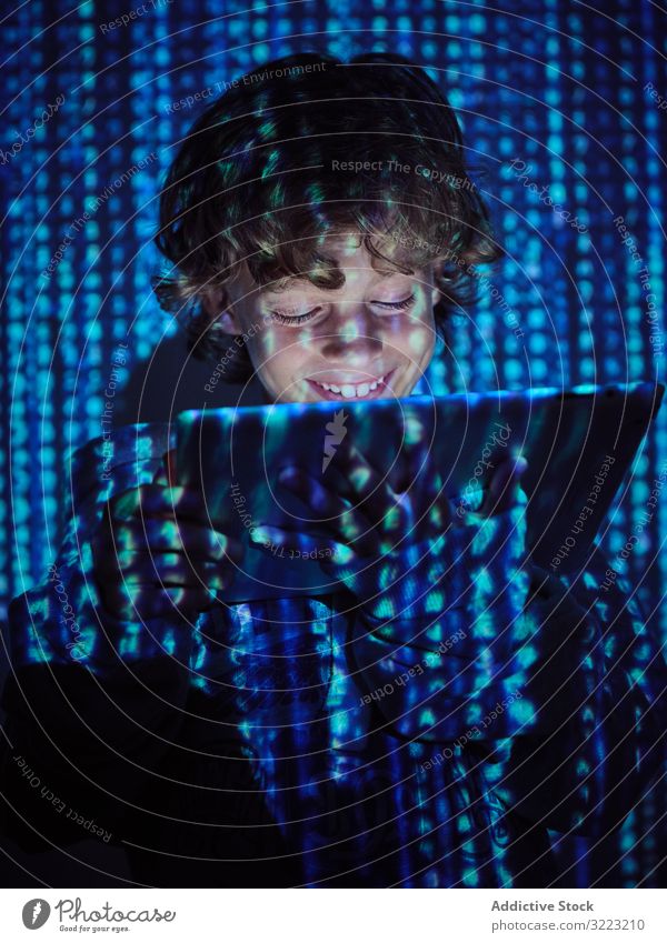 Hacker-Junge mit Tablette Code Datenbank wenig benutzend Programmierer Virus digital Kennwort Software Kind Gerät Apparatur Browsen Betrug Website Symbol glühen