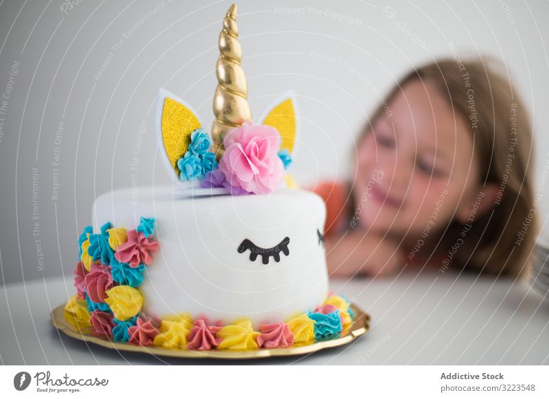 Heller Einhorn-Kuchen für zufriedenes Mädchen bei Tisch Party Kindheit hell Glück wenig Feiertag Geburtstag Dekoration & Verzierung zu feiern heiter Spaß