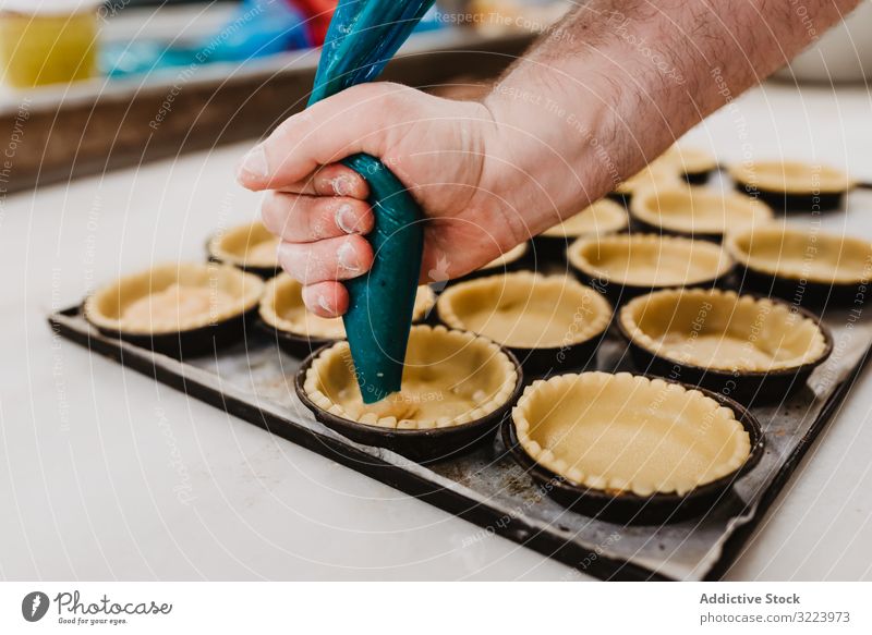 Erntebäcker, der Teig auf einem Blech auspresst Konditor Bäckerei Teigwaren drücken Tablett Keks Arbeit Küche Vorbereitung professionell Lebensmittel Papier