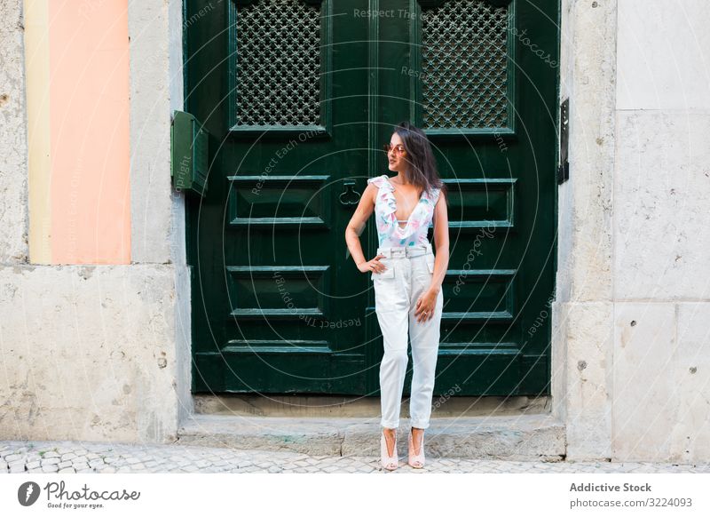 Selbstbewusste, stilvolle Frau mit Sonnenbrille steht auf der Straße in der Stadt stylisch modern trendy schön stehen Gebäude selbstbewusst malerisch Portugal