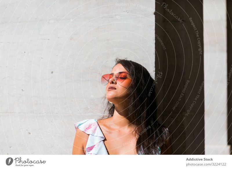 Verträumte stilvolle Frau mit Sonnenbrille steht auf der Straße der Stadt stylisch verträumt trendy schön Gebäude Portugal Accessoire Lissabon Muster jung