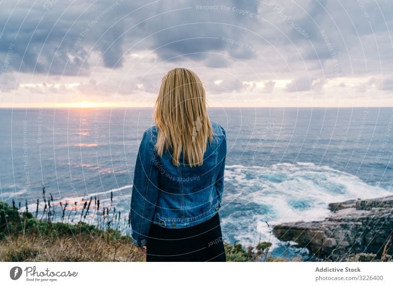 Frau am Meeresufer vor düsteren Wolken Horizont Meereslandschaft Sonnenuntergang Harmonie Kontemplation bedeckt Kälte malerisch Ausflug reisen ruhig