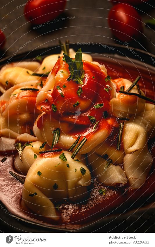 Platte mit köstlichen Ravioli mit Tomatensauce auf dem Tisch serviert Teller lecker Italienisch gekocht Kraut Feinschmecker Gabel Exquisit Serviette Rosmarin