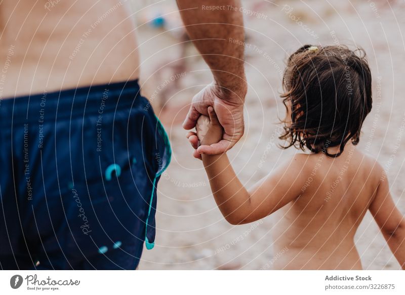 Großvater und Enkelin gehen am Strand und halten sich an den Händen Hände schütteln Händchenhalten Urlaub Familie Angebot umarmend älter Kind Mädchen genießend
