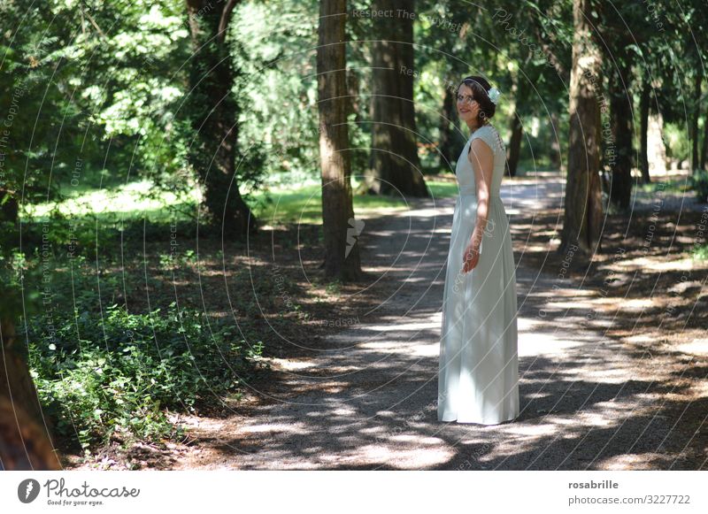 junge Frau in elegantem weißem Kleid auf Weg unter Bäumen zurückblicken Blick in die Kamera Blickkontakt feminin Park Wald Erwachsene Mensch schön Porträt
