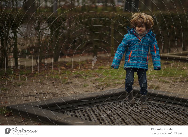 Junge springt auf einem Trampolin Blick nach vorn Ganzkörperaufnahme Schwache Tiefenschärfe Unschärfe Tag Außenaufnahme Farbfoto Dynamik Aktion fliegen hüpfen