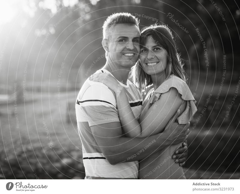 Paar, das mit glücklichem Lächeln in die Kamera schaut Liebe Glück Urlaub sonnig tagsüber Mann Frau Erwachsener Flitterwochen Sommer Natur Ufer Küste