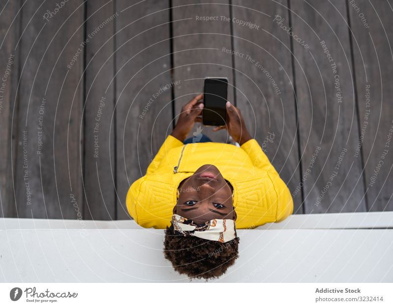 Ruhige Frau benutzt Mobiltelefon modern sich[Akk] entspannen fettarm Großstadt Straße ruhig Afroamerikaner Wand Gebäude jung Freizeit Glück Denken Kontemplation