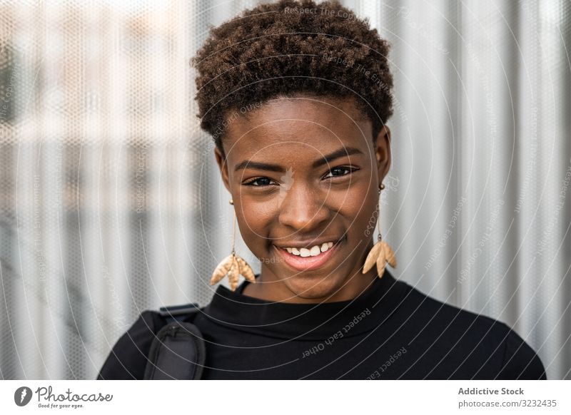 Konzentrierte weibliche Nutzung eines Mobiles in der Nähe eines städtischen Gebäudes Frau Straße urban Afroamerikaner stylisch schwarz Glück Lächeln modern