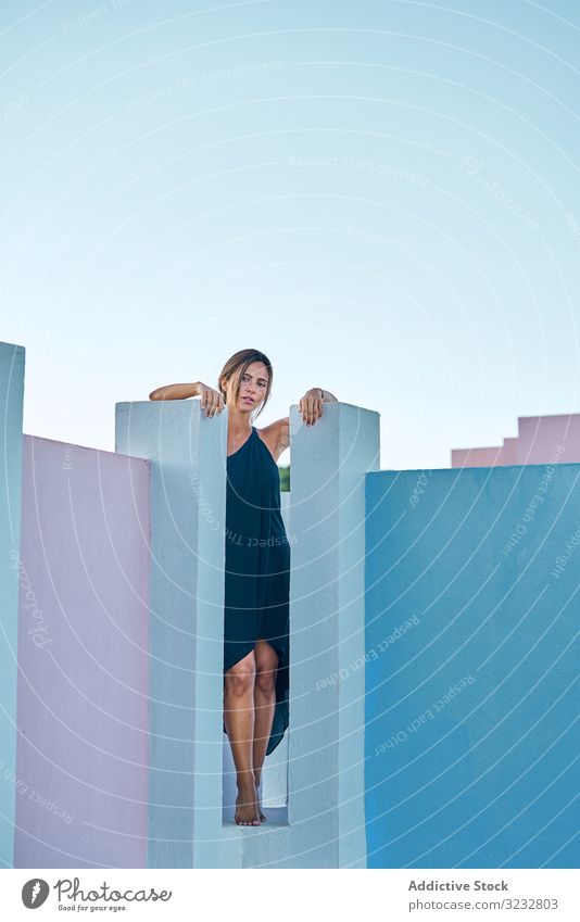 Frau steht auf der Spitze eines blauen Gebäudes lässig elegant Konstruktion Struktur geometrisch Architektur urban Fassade Wand abstrakt Außenseite Innovation