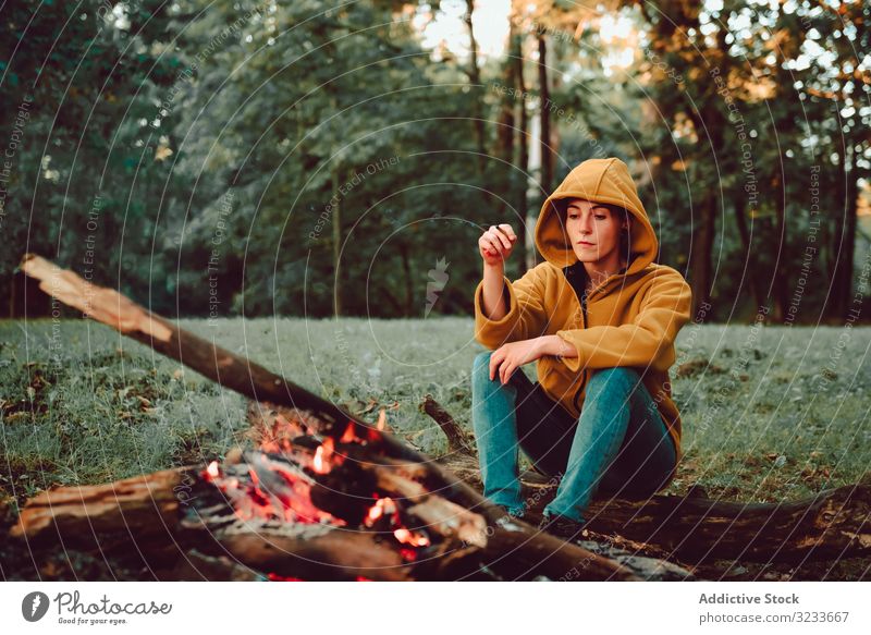 Reisende Frau wärmt Hände am Lagerfeuer auf Waldwiese warm ruhig Flamme nachdenken sich[Akk] entspannen Einsamkeit ruhen Windstille Stille Brennholz Freiheit