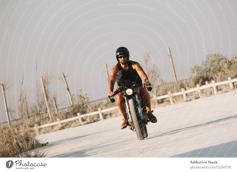 Porträt eines bärtigen Motorradfahrers mit Helm und Sonnenbrille auf seinem  Motorrad sitzend - ein lizenzfreies Stock Foto von Photocase