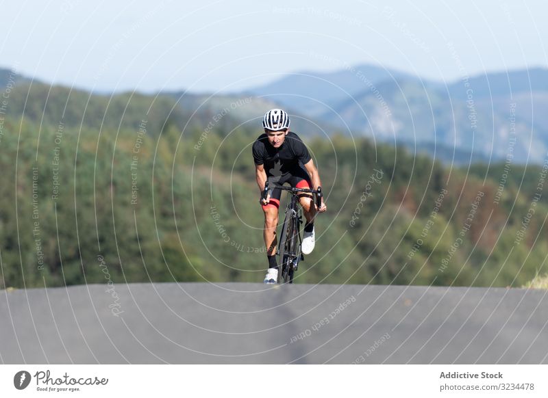 Profi-Radfahrer fährt Fahrrad im Park Mitfahrgelegenheit Sportler Rennen professionell Weg sonnig tagsüber männlich Sicherheit Schutz Schutzhelm Schutzbrille