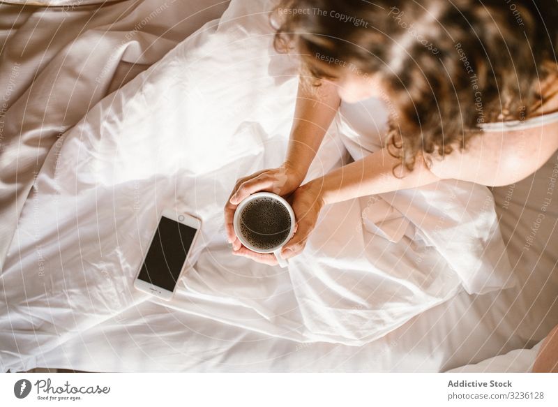 Frau mit Heißgetränk und Smartphone im Bett Kaffee verwenden Nachricht heimwärts Text Information prüfen Fokus teilen Browsen trinken leerer Bildschirm Surfen