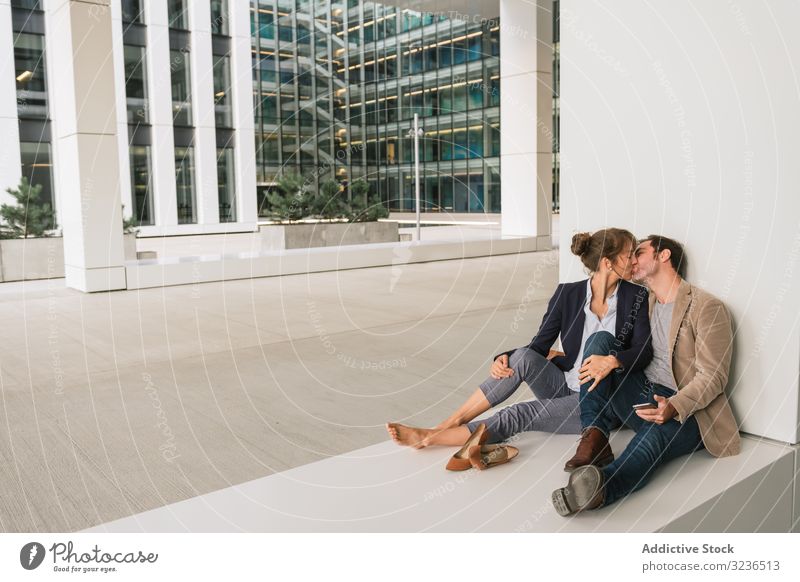Geschäftsleute umarmen sich und nutzen Smartphone auf der Straße Paar Umarmung benutzend soziale Netzwerke Gebäude sitzen ruhen Großstadt Business Zusammensein