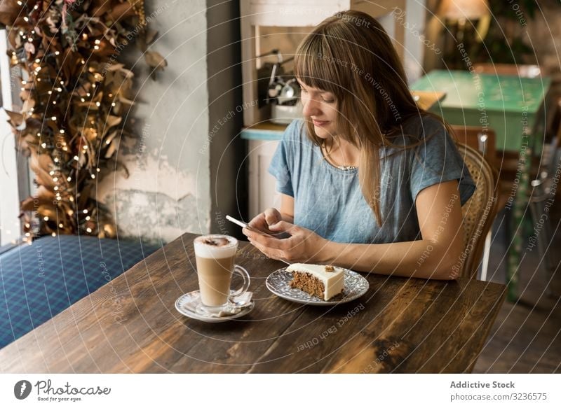 Frau benutzt Smartphone im Cafe Café benutzend Tippen Kaffee Lifestyle jung Mobile Nachricht heiter Freizeit trinken SMS lässig Restaurant Sitzen Halt