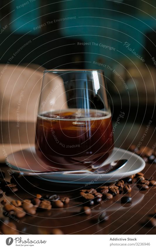 Glas Heißgetränk in Komposition mit Hut und Kaffeekörnern auf Holztisch trinken Bohne Getränk Erfrischung Koffein süß Geschmack Untertasse lecker Aroma