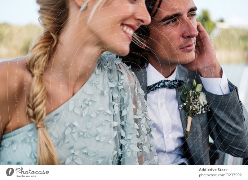 Paar hält sich beim Sitzen auf dem Boot an den Händen striegeln Braut Hochzeit Heirat Liebe Feier Ehefrau Frau Fröhlichkeit heiter umarmend Partnerschaft