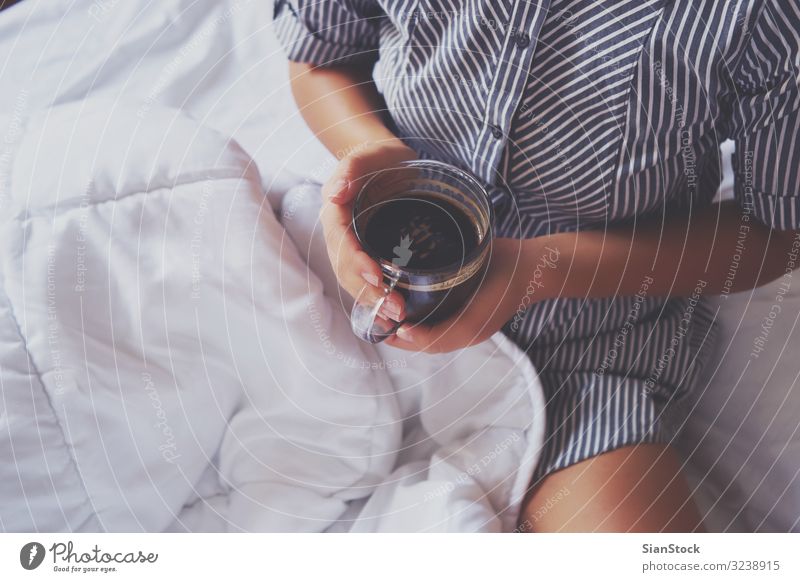 Frauenhände halten eine Tasse heißen Kaffee im Bett. schön Leben Erholung lesen Schlafzimmer Erwachsene Hand Buch Wärme natürlich niedlich oben weich weiß
