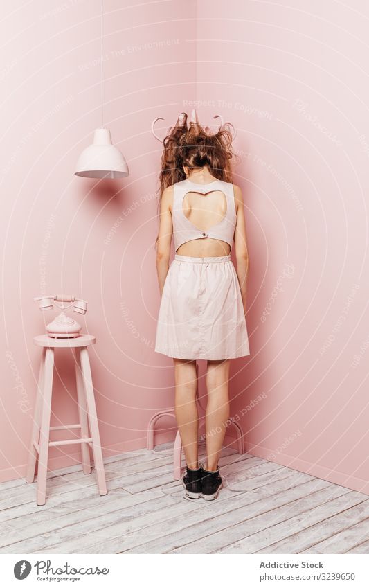 Rückenansicht eines jungen Mädchens Telefon Wand Lampe im Innenbereich rosa unzufrieden lange Haare wütend passiv Stehen unglücklich Frisur Verlust Stress