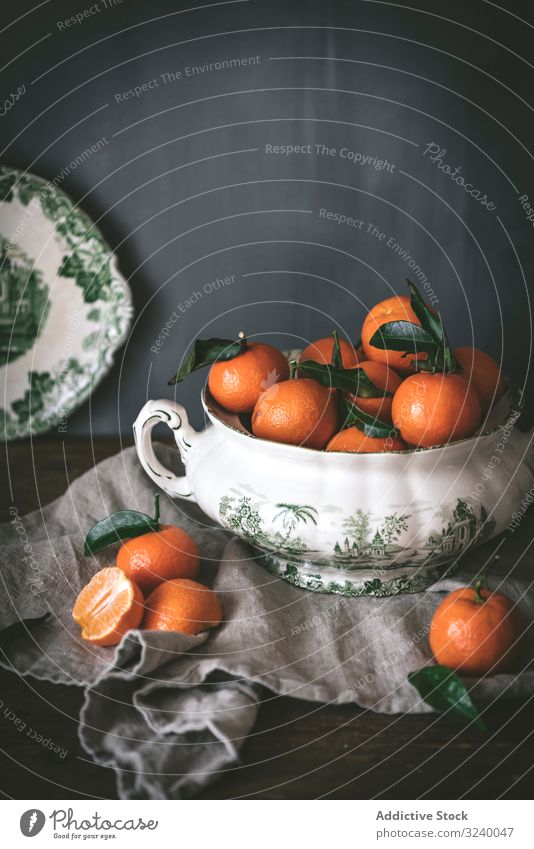 Orangefarbene Mandarinen in Keramik-Ornamentschale auf Holztisch anspruchsvoll Frucht Gesundheit klassisch Schalen & Schüsseln Zusammensetzung Stillleben Kunst
