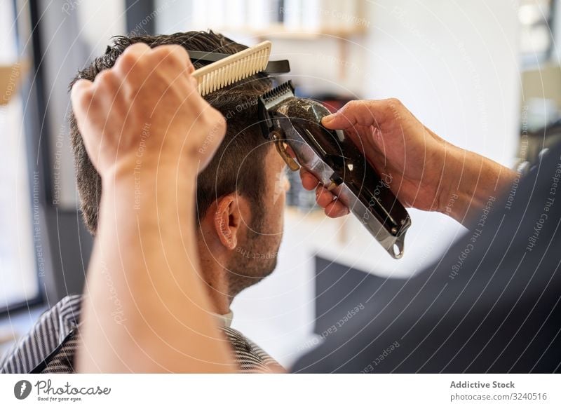 Detail der Hände eines Friseurs, der die Haare mit einem Kamm und einem Rasiermesser schneidet Detailaufnahme Rasierapparat geschnitten Barbershop Frisur Arbeit