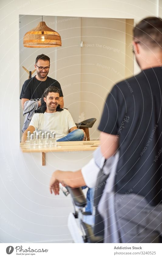 Vertikales Foto eines Friseurs, der einem Kunden vor einem Spiegel mit einem Handtuch die Haare trocknet vertikal Saloon Stuhl Produkte Barbershop Trocknung