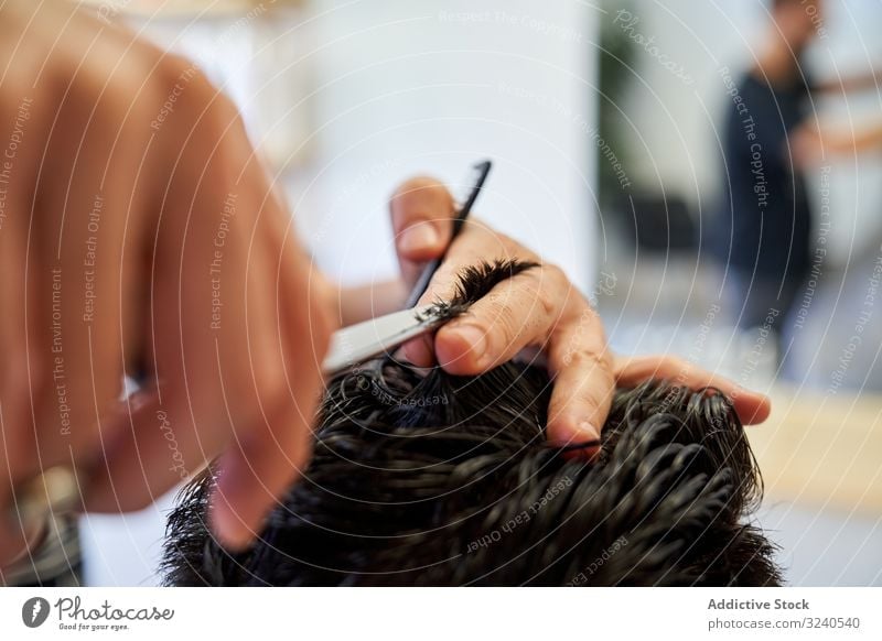 Detail einer Hand von einem Friseur, der einem Kunden mit Schere und Kamm die Haare schneidet Haarschnitt Salon Klient Haarpflege menschlich Barbershop Pflege