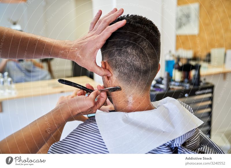 Detail der Hände eines Friseurs, der einem Kunden mit einem Rasiermesser die Haare schneidet Rasierer handgefertigt altehrwürdig Nacken Dienst Spiegel Reflexion