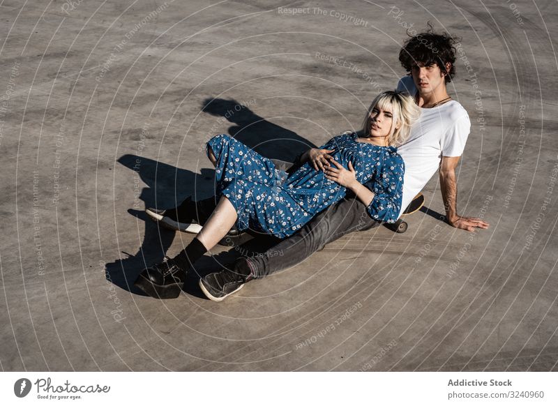 Trendiges Paar sitzt gemeinsam auf dem Skateboard auf der Straße träumen abstützen Zusammensein Liebe sinnlich amour Seelenverwandter Gefühle Vertrauen