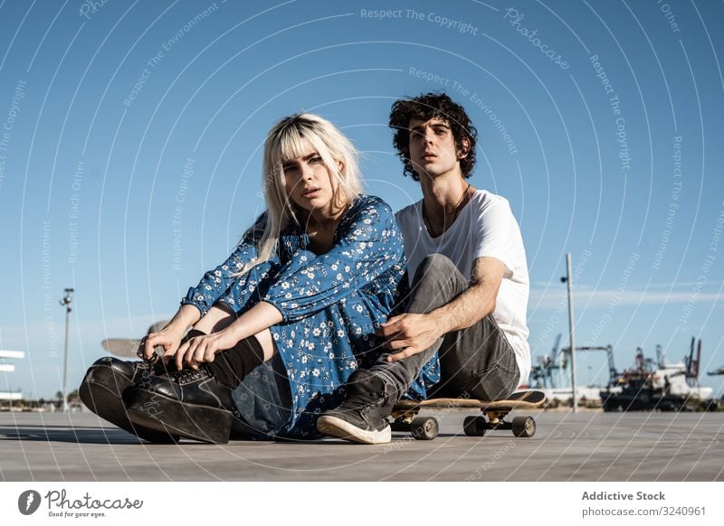 Trendiges Paar sitzt gemeinsam auf dem Skateboard auf der Straße träumen abstützen Zusammensein Liebe sinnlich amour Seelenverwandter Gefühle Vertrauen