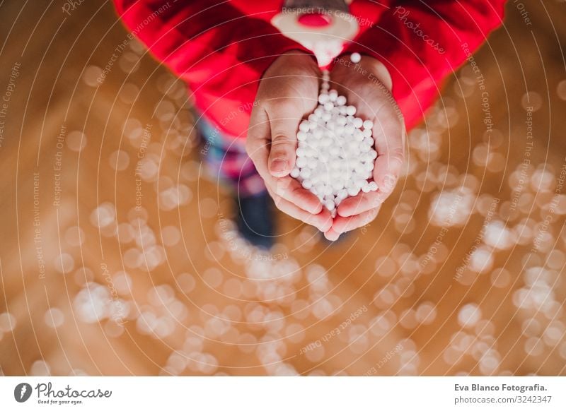 Kind hält künstliche Schneeflocken zu Hause. Freude schön Spielen Winter maskulin Kleinkind Mädchen Junge Hand 1 Mensch 3-8 Jahre Kindheit Pullover träumen