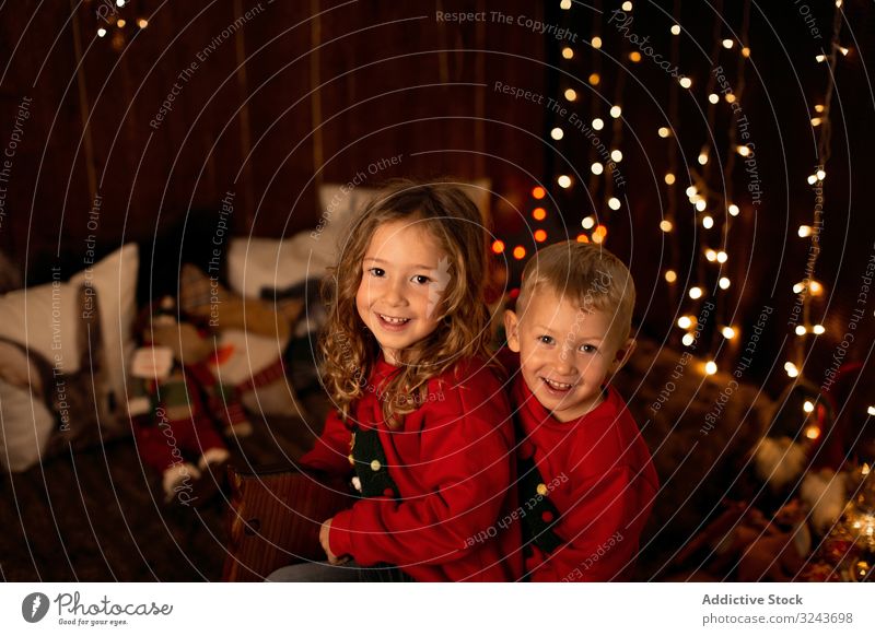 Geschwister sitzen zu Weihnachten auf einer hölzernen Pferdeschaukel Kind dekorierend Baum Feier Dekoration & Verzierung heimwärts Mädchen Kindheit Saison